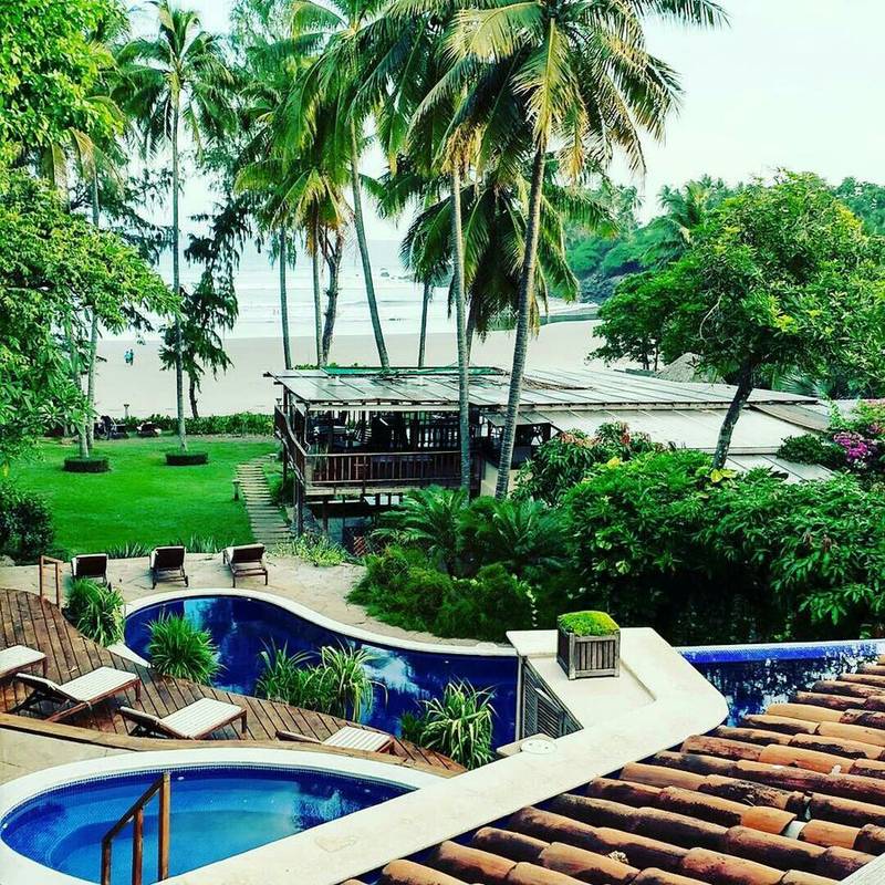Pools and beachfront palapa at Las Flores Resort